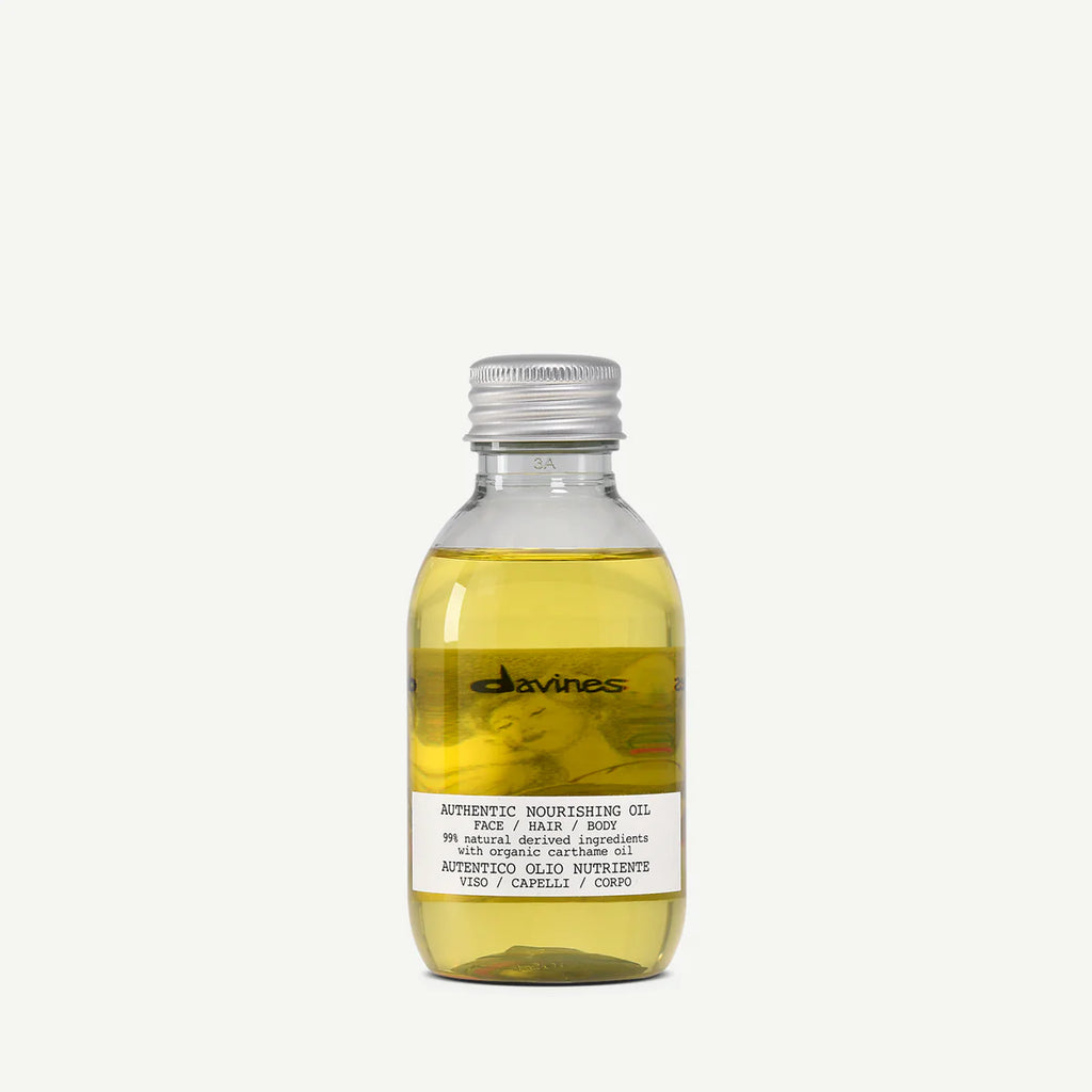 Flaska med Authentic Nourishing Oil, en vårdande olja för ansikte, hår och kropp med naturliga ingredienser för fukt och näring.