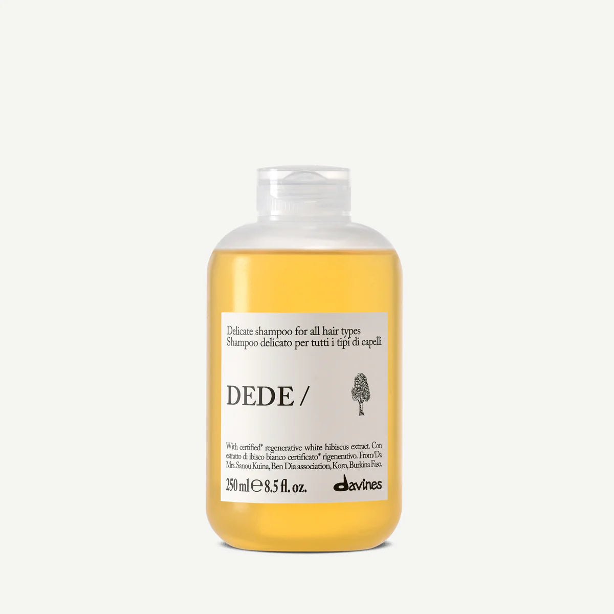 Flaska med Dede Delicate Shampoo i guldfärgat schampo, miljövänlig hårvårdsprodukt för skonsam rengöring av alla hårtyper.