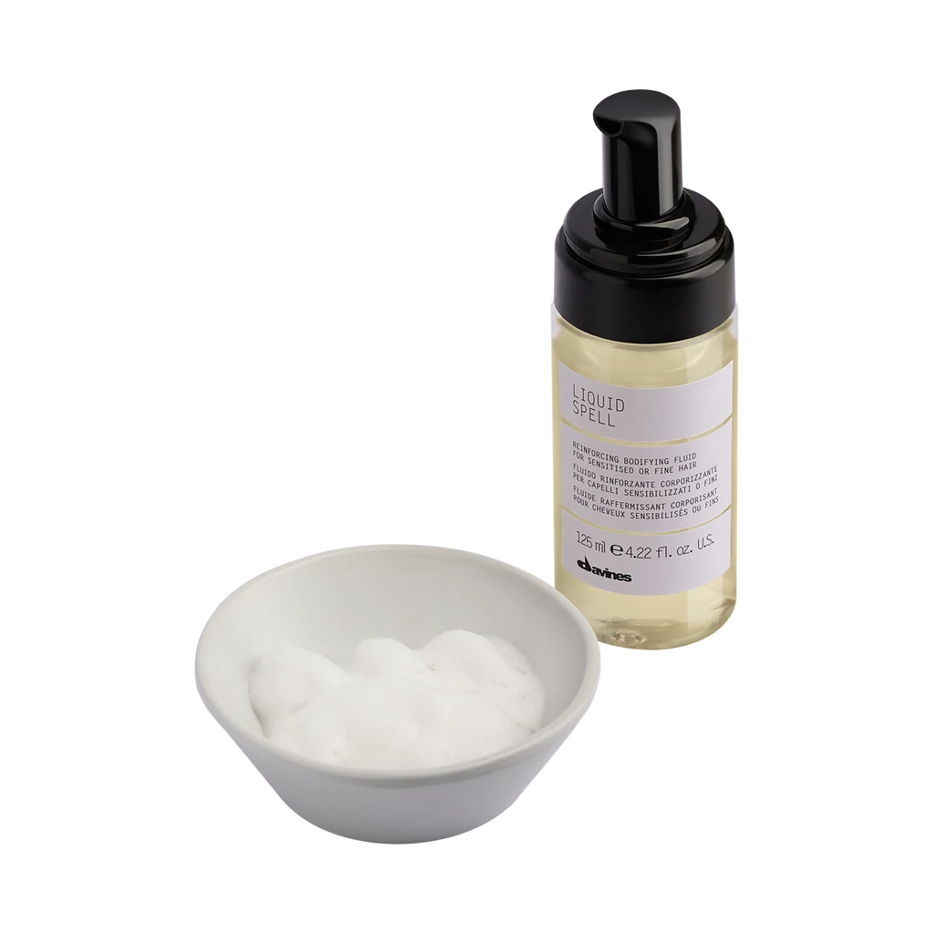 Liquid Spell volymgivande skum för fint hår från Davines, med pumpflaska och skum i vit skål, miljövänlig hårvårdsprodukt för styling.
