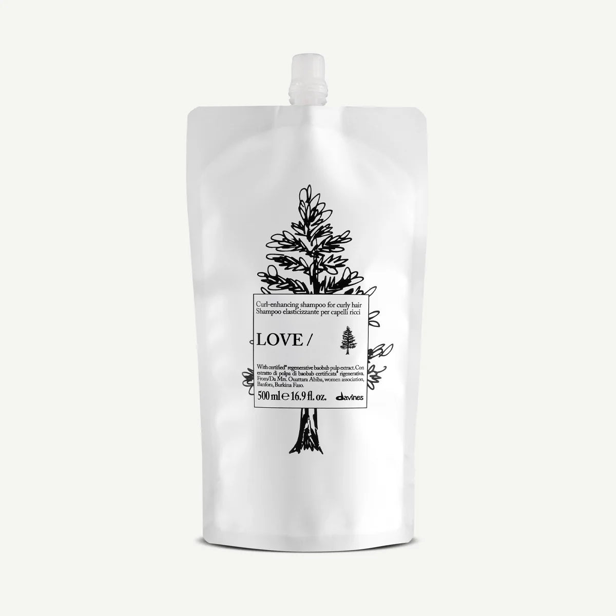 Vit påse med svart illustration av träd och text, innehåller Love Curl Enhancing Shampoo i miljövänlig förpackning för vård och styling av lockigt hår.