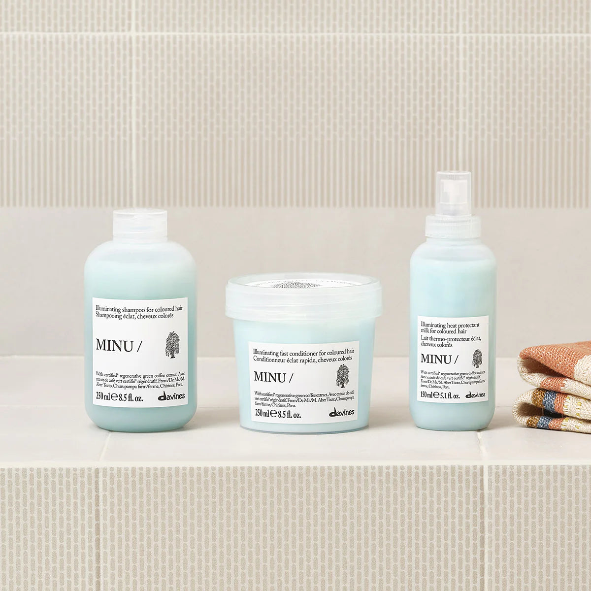 Minu Illuminating Fast Conditioner i en ljusblå förpackning tillsammans med matchande hårvårdsprodukter från Davines, presenterade på en neutral bakgrund.