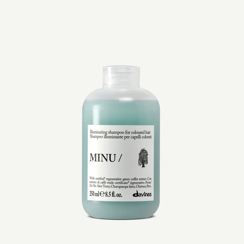 Minu Illuminating Shampoo i en transparent flaska med blågrönt innehåll, en miljövänlig schampo för färgat hår från Davines.