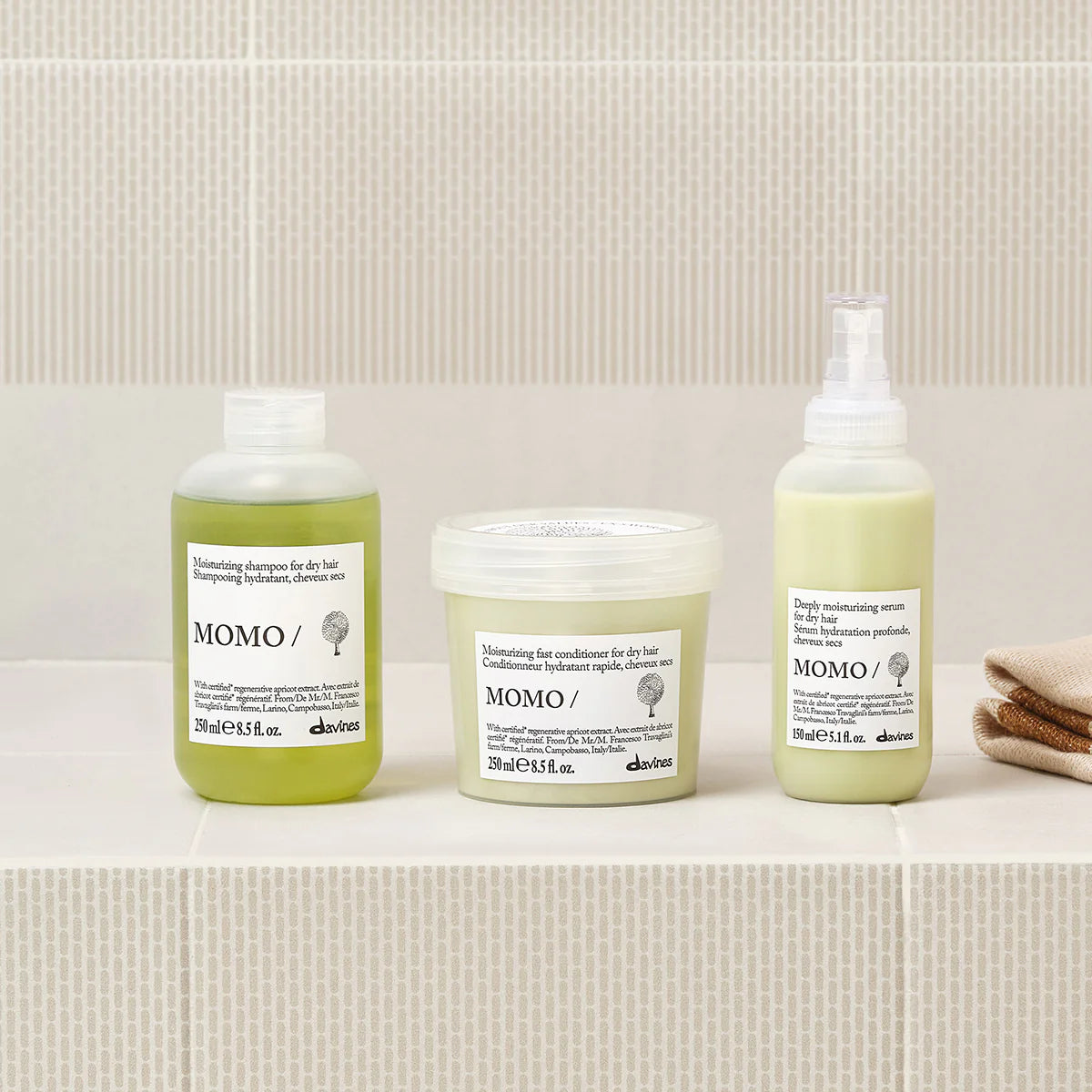 Momo Moisturizing Fast Conditioner tillsammans med andra miljövänliga hårvårdsprodukter i minimalistisk förpackning på beige kakelbakgrund.