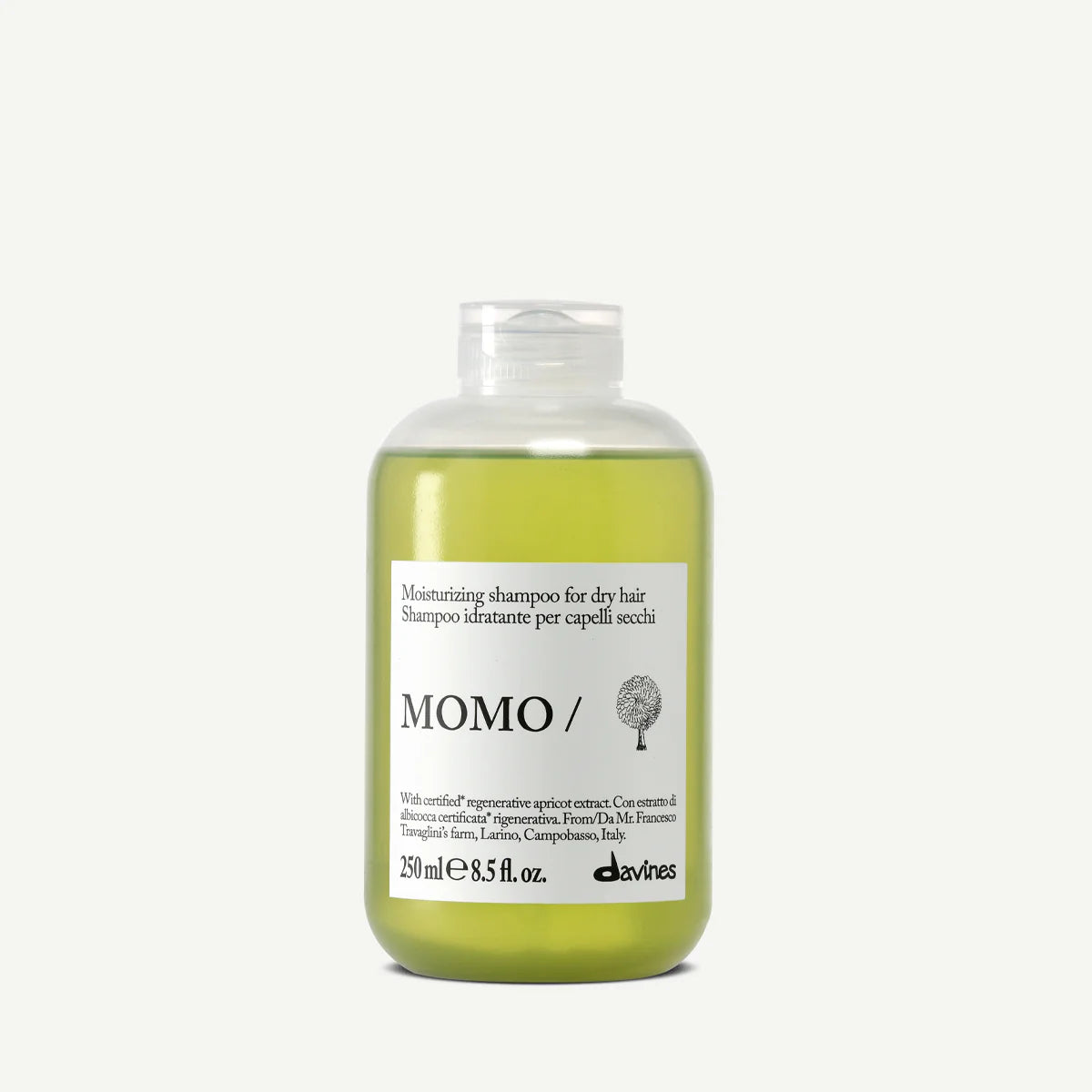 Flaska med Momo Moisturizing Shampoo, ett milt schampo som återfuktar och vårdar torrt hår, i en transparent behållare med grön vätska.
