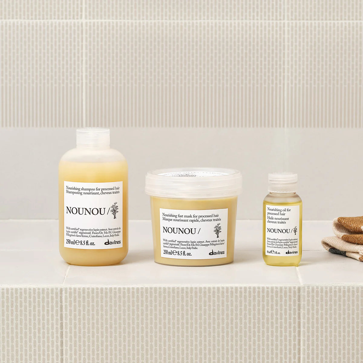 Nounou Nourishing Oil i en elegant flaska tillsammans med matchande hårinpackning och schampo, miljövänliga hårvårdsprodukter för vårdande och närande hårvård.