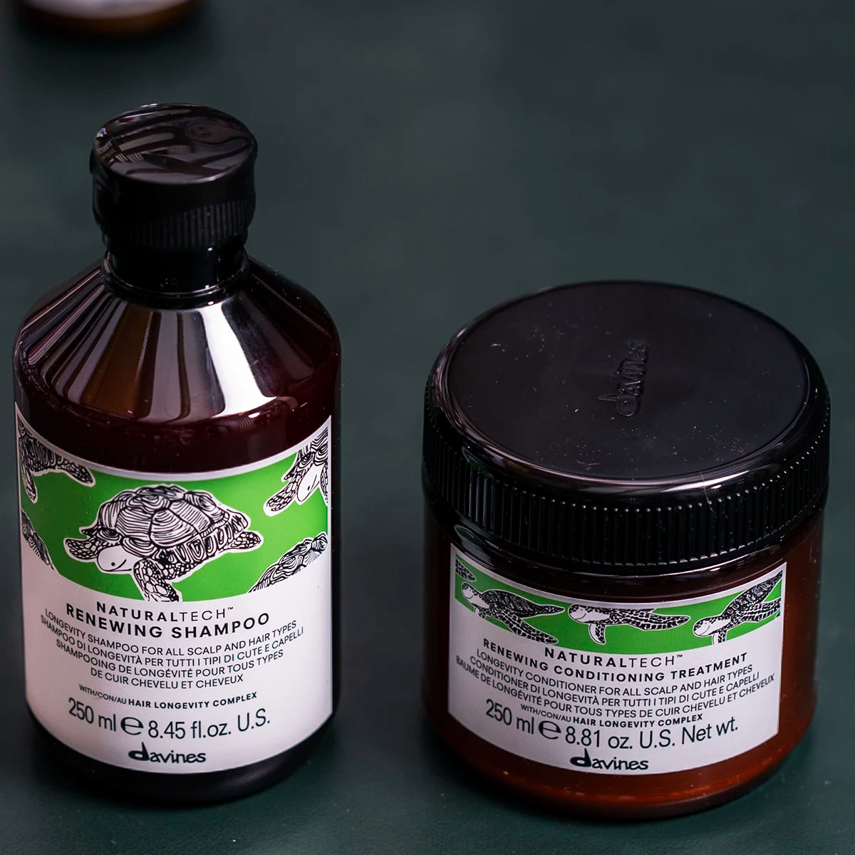 Bild på Naturaltech Renewing Conditioning Treatment tillsammans med schampo i bruna förpackningar med gröna etiketter, en hårinpackning för vård av hår och hårbotten.